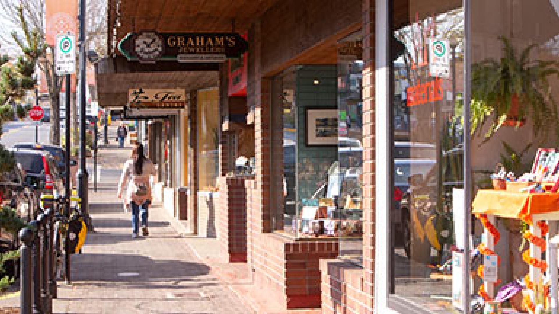 Downtown Courtenay 5th Street, downtown storefront windows with a person walking in the distance heading west