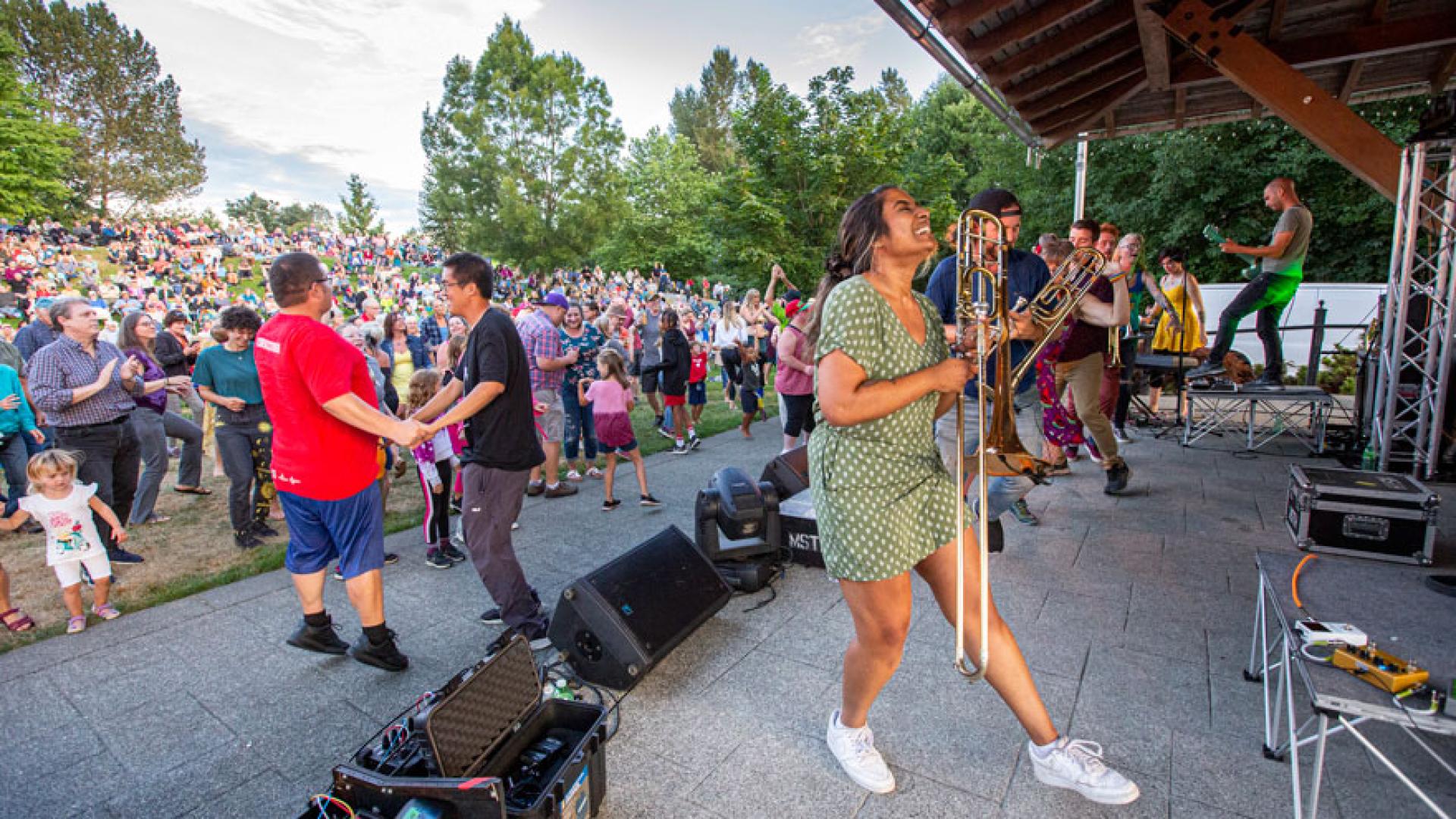 A diverse crowd dancing to live music during a previous Simms Summer Concert performance.