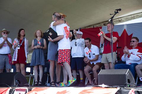 Brian "Fuzz" Morissette receiving an award from Mayor Wells on a stage