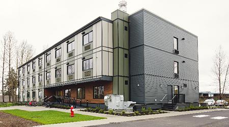 Exterior of "The Junction" 988-8th Street building. The building is box-shaped and grey.